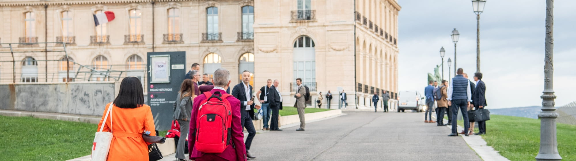 Des participants à Top Transport Europe marchant vers le Palais du Pharo. 