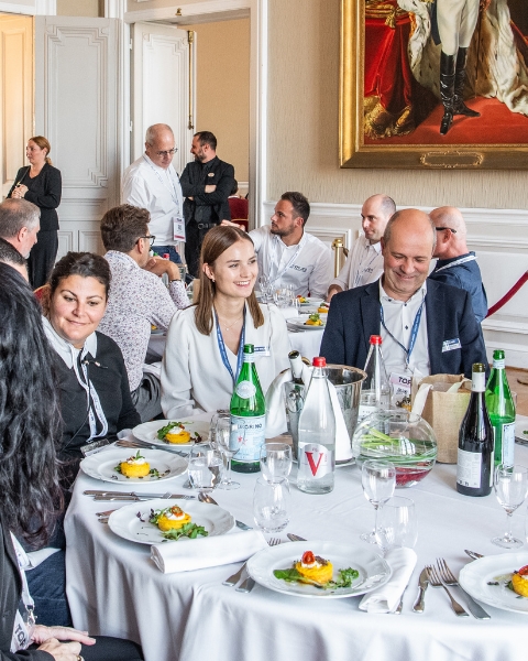 Professionals sharing a meal and engaging in conversation at the Top Transport Europe event.