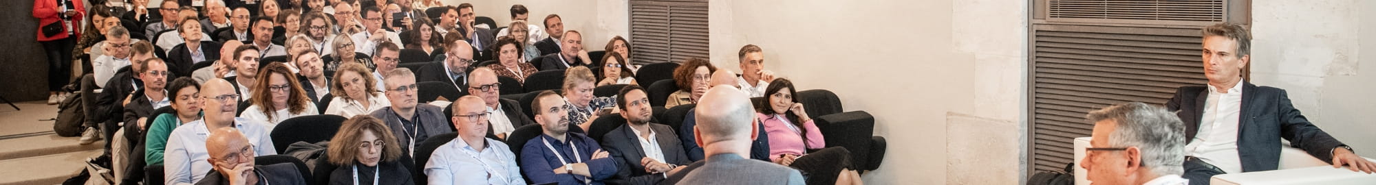 Speakers present a transport theme in a packed conference room.