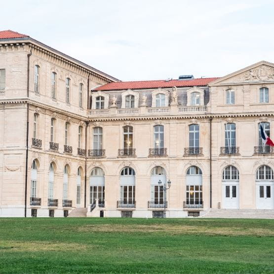 Vue rapprochée du Palais du Pharo à Marseille, montrant les détails architecturaux du bâtiment historique et les pelouses environnantes.
