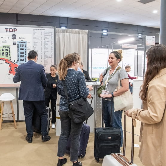 Two women talking to Top Transport Europe with suitcases.